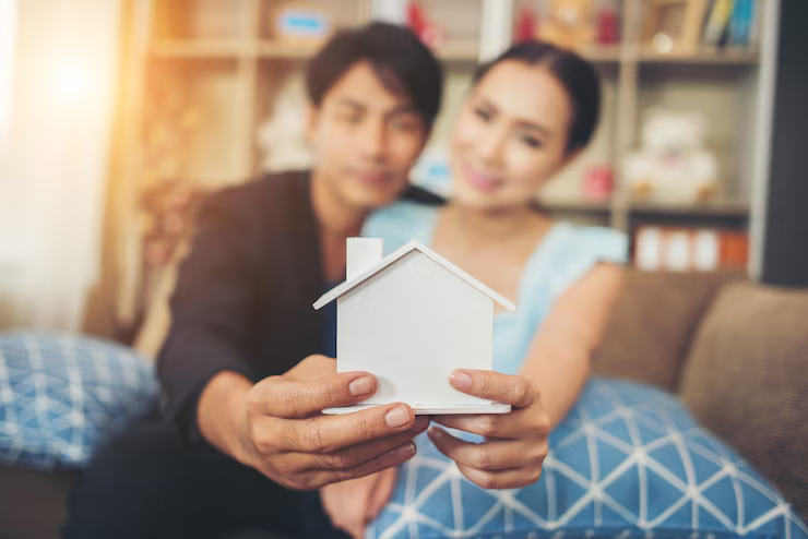 young-couple-holding-white-miniature-house-living-room_1150-5270 young-couple-holding-white-miniature-house-living-room_1150-5270